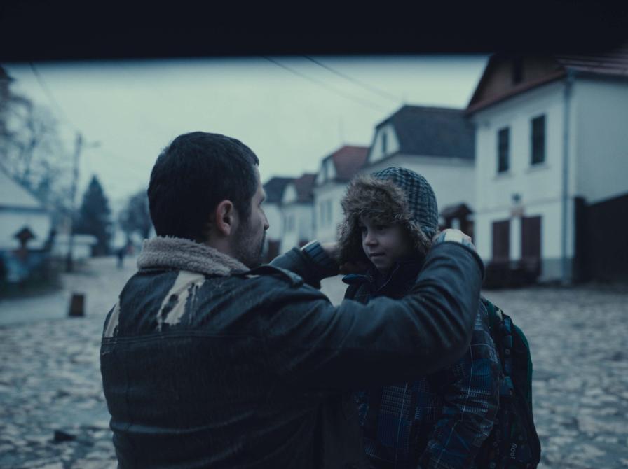 mand på hug foran dreng, dreng får hætte på